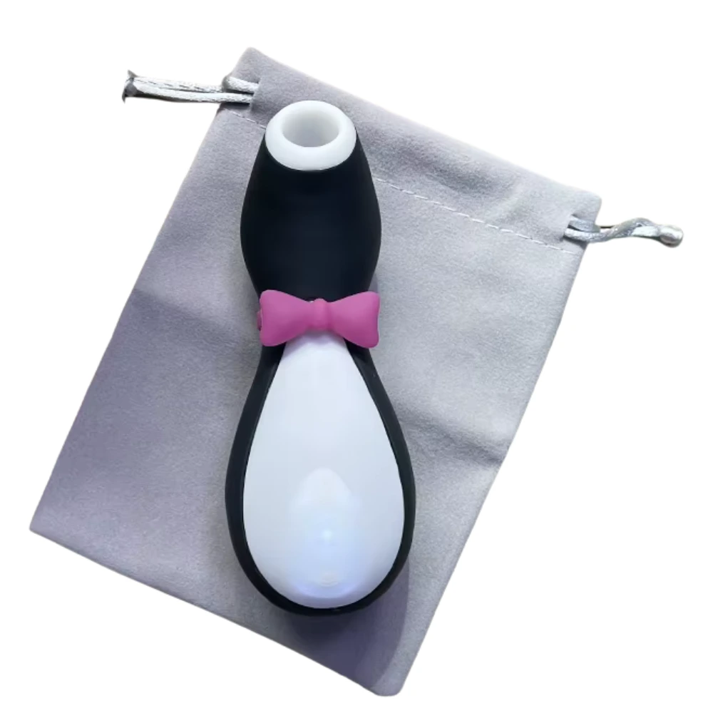 The Penxie – Penguin Clitoral Sucking Vibrator resting on a soft gray drawstring pouch, highlighting its playful penguin design and travel-ready convenience.