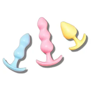 A set of three pastel-colored silicone butt plugs arranged diagonally, showing the smooth, tapered design and flared bases for safe and comfortable use.