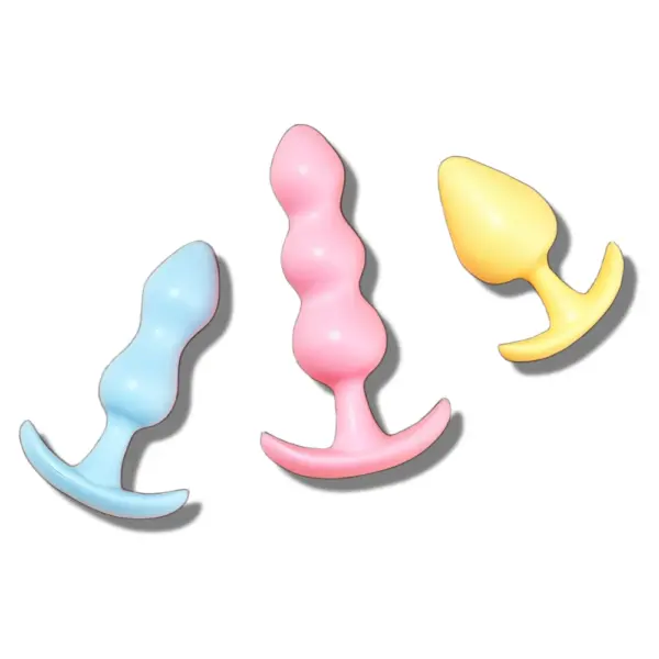 A set of three pastel-colored silicone butt plugs arranged diagonally, showing the smooth, tapered design and flared bases for safe and comfortable use.