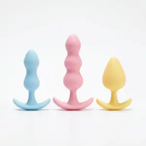 Softa silicone butt plug set in blue, pink, and yellow with tapered shapes and flared bases on a white background