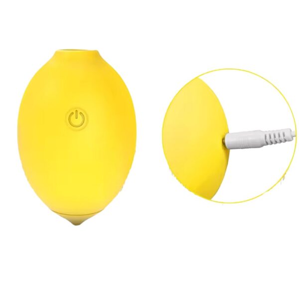 Close-up image of the Lemon Shaped Suction Vibrator by Citric Lust with a charging cable inserted, highlighting the rechargeable design and smooth finish.