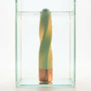 Pocket Passion USB rechargeable mini bullet vibrator in green submerged in water, showcasing waterproof design with compact curved shape and metallic base