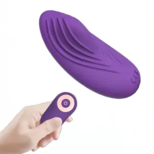 Hand holding the remote control while the curved Secret Purr vibrator hovers above, highlighting its ergonomic design for discreet wearable pleasure.