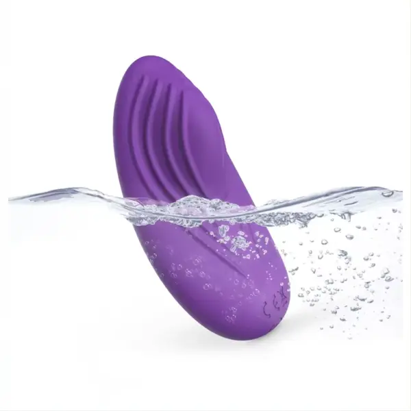 Waterproof purple Remote Controlled Vibrating Panties -Secret Purr vibrator half-submerged in water, showcasing its curved ridges and smooth silicone surface