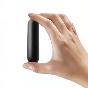 A hand holding a compact black silicone rechargeable bullet vibrator vertically between two fingers, emphasizing its discreet size.