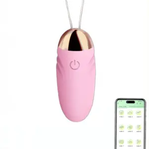 Close-up of the Small Egg Vibrator Wireless in pink with a rose gold tip and a single power button, shown alongside a smartphone displaying app-controlled vibration modes.