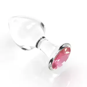 Angled view of the Crystal Clear Butt Plug – Clear Love, showing its clear glass body and faceted pink gem at the base against a white background.