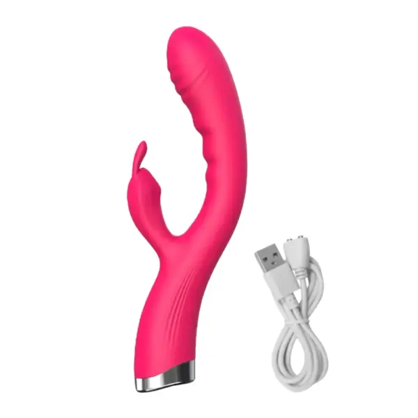Angled view of the pink Flutter Flick dual G-spot and rabbit vibrator—featuring a curved, textured silicone shaft and small clitoral arm—shown next to its white USB magnetic charging cable.