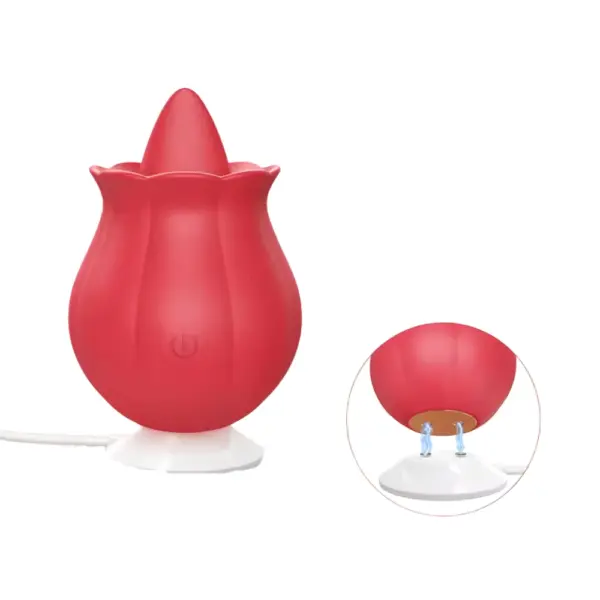 The red “Playful Pout” rose-shaped licking vibrator seated on its white magnetic charging base, USB cable attached, with a circular inset showing the two gold charging pins on the vibrator’s underside.