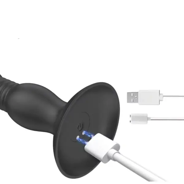 The Thrusting Butt Plug – Vibrato shown with a magnetic USB charging cable connecting to the base, highlighting its rechargeable and cordless design.