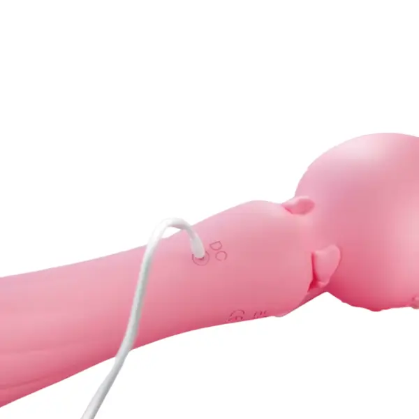Close-up of the Personal Wand Massager – PurrPlay being charged via a DC cord, plugged into the base near the bowtie on the neck of the massager.