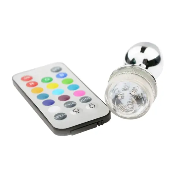 The LED Light Butt Plug – Booty Glow lying next to its remote control, highlighting the transparent LED cap and internal chip design.