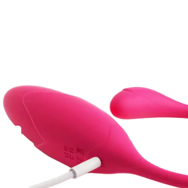Wearable Love Egg – Winkie shown plugged in with a white charging cable inserted near the tail on its sleek silicone body.