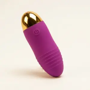 The Remote Control Egg Vibrator – Velvet Pulse shown without the remote, featuring a textured grip, curved shape, and metallic gold tip with a power button icon.