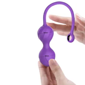 Close-up of the Amivra Kegel egg held between fingers, showing labeled measurements of 34mm and 36mm for the upper and lower weights.