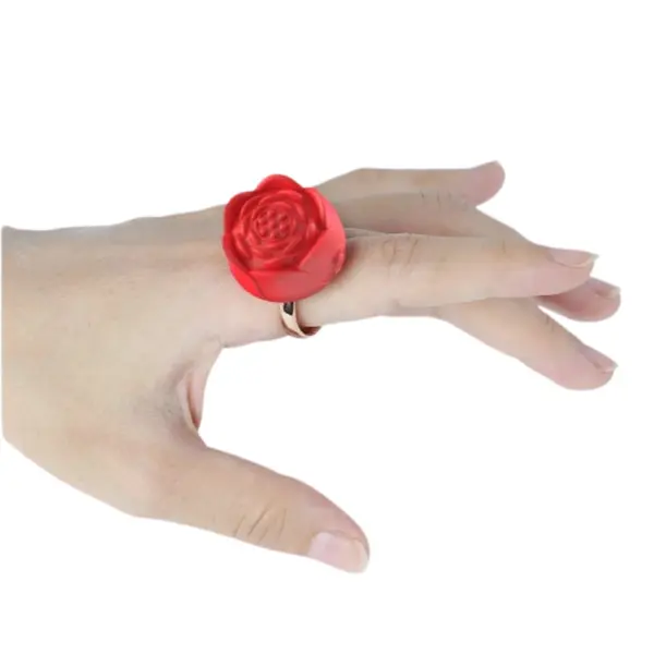 A hand wearing the red Bloomé Discreet Clitoral Stimulator Ring, highlighting the comfortable fit and realistic rose-shaped design.