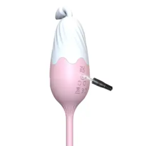 Close-up of the Thermavie silicone heated love egg being charged through a small side port, showing its smooth pink silicone finish.