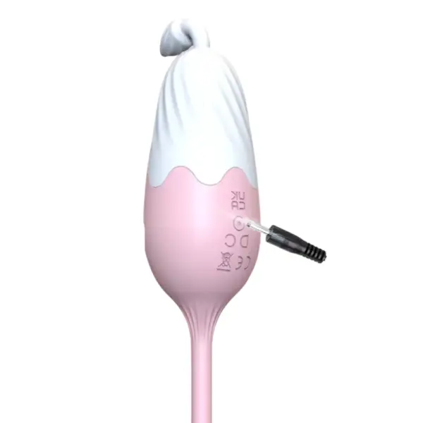 Close-up of the Thermavie silicone heated love egg being charged through a small side port, showing its smooth pink silicone finish.