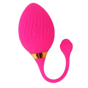 Close-up of the Veloura love egg in vibrant pink with a textured silicone surface, gold accent ring, and flexible retrieval tail.