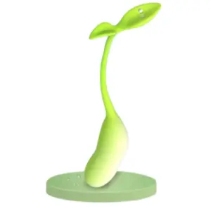 Verdanta vibrator standing upright on a matching green charging base, highlighting the magnetic charging pins on the leaf-shaped handle.
