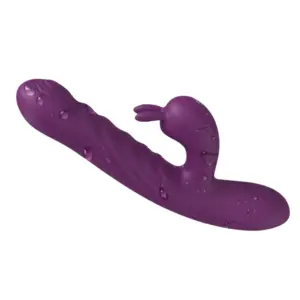 PlushPounce rabbit vibrator shown flat with water droplets on the surface, highlighting its waterproof silicone build and contoured curves.
