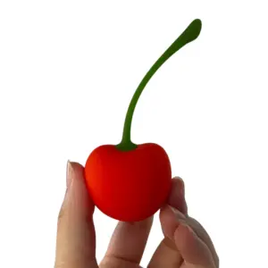 Cherry shaped bullet vibrator – CherryPop held between fingers to show its compact, playful size and soft silicone texture.