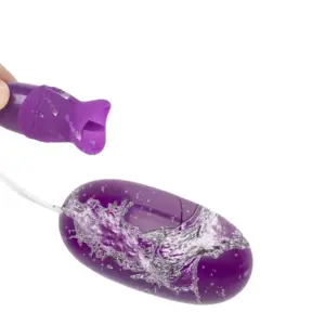 Purple VibeLuxe vibrator shown with water splashing over the bullet and tongue attachment, emphasizing its water-resistant design.