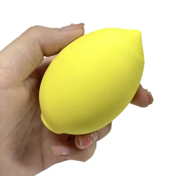 Lemon Shaped Suction Vibrator – Citric Lust resting in an open palm, highlighting its smooth matte finish and discreet, citrus-inspired design.