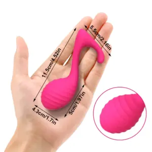 The Notiva love egg shown in a hand for scale with overlayed dimensions of 4.52 inches in length and 1.97 inches width, emphasizing its compact and textured build.
