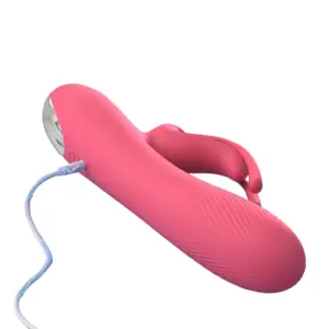 Close-up of the HarePlay vibrator connected to a charging cable, showing the metallic base and silicone body with diagonal textured detailing.