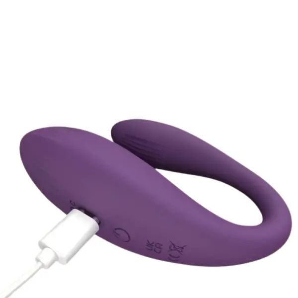 Close-up of the Vibora Couples Vibrator being charged via USB, showing the power button and certification markings on the silicone surface.